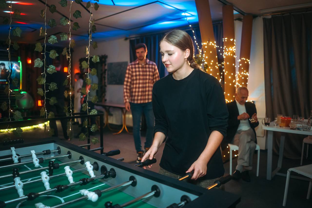 Коллеги играют в настольный футбол на тимбилдинге в лофте Folium_Place
